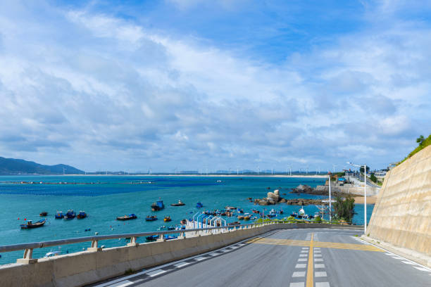 This is a seaside road where you can see the sea in the distance.