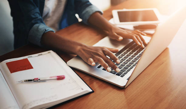 istock Woman hands, typing and laptop with work from home and learning notes. Student, female person and computer working with paperwork, notebook and writing in a house doing web research with mockup 2161298100