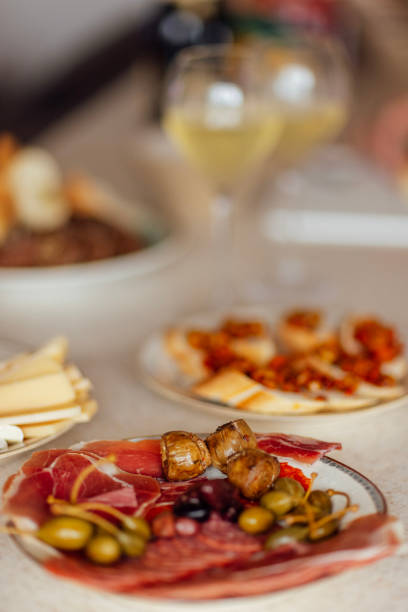 istock Two glasses of cool champagne and plates with various snacks on a table 2161299891