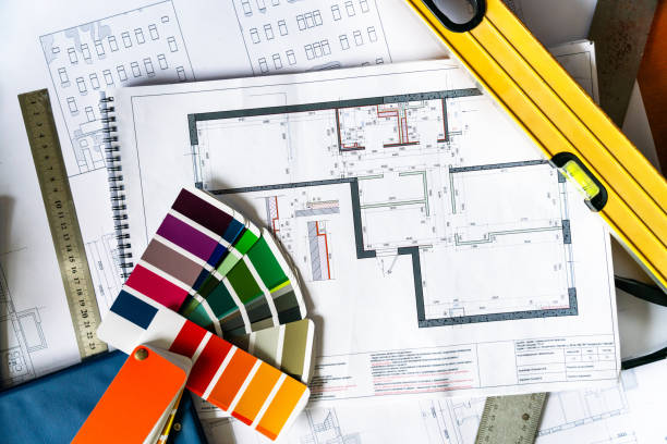 istock An architectural blueprints, color swatch palette and construction work tools on the desk, directly above view 2161302244