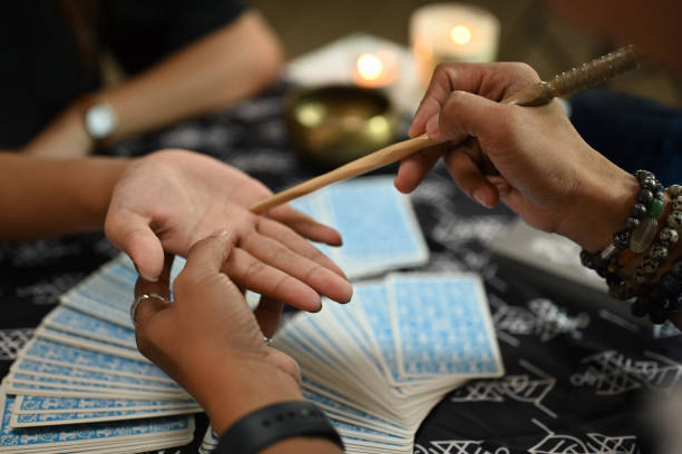 istock Close up fortune teller reading palm forecasting future of client in dark room. Divination concept 2161302469