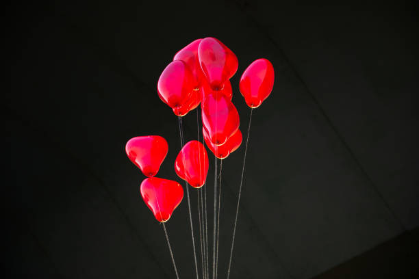 Tokyo, Japan - February 8, 2025: A close-up shot of a St. Valentine's Day decoration in a jewelry store window in Ginza. The decoration features a cluster of small, red heart-shaped balloons with the words 'St. Valentine's Day' written on one, creating a romantic and festive display.