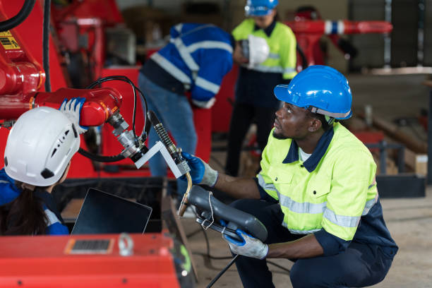 istock Group of engineer control robot arm system welding at production plant factory. Technician working with robot arm system welding 2161308449