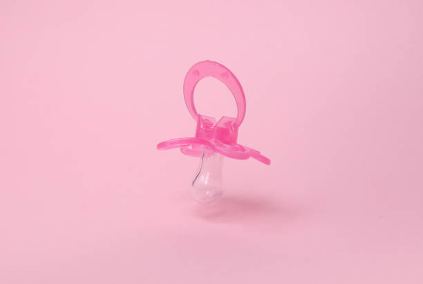 Newborn baby wrapped in a soft blanket, lying on a bed with a pacifier
