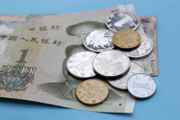 A close-up of a 1 yuan coin on the background of a column of coins.
