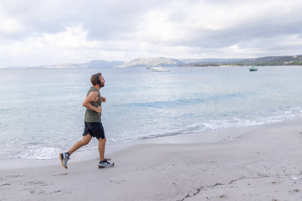 istock Man Running on Beach with Headphones 2161315218