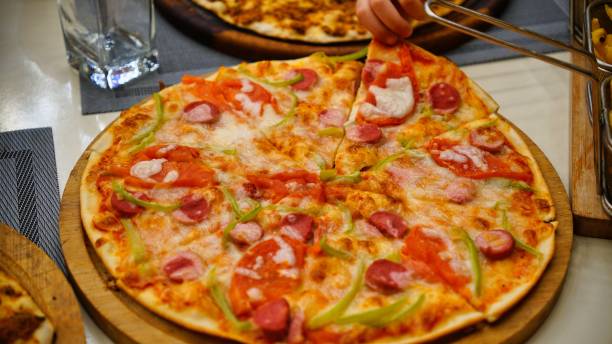 istock Pizza Slice Being Removed From Wooden Board 2161316002