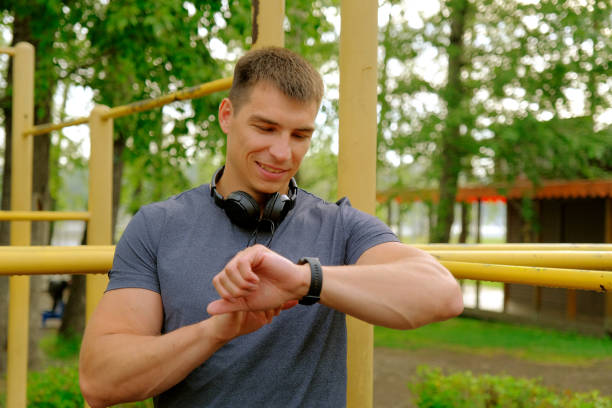 istock Smiling man uses smart watches during outdoors workout 2161318325