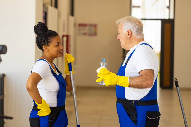istock Multiracial female and male janitors talking while taking a break from work 2161322749