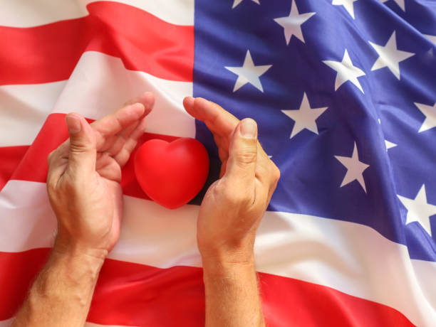 istock Red heart in the hands on US flag background. 2161325766