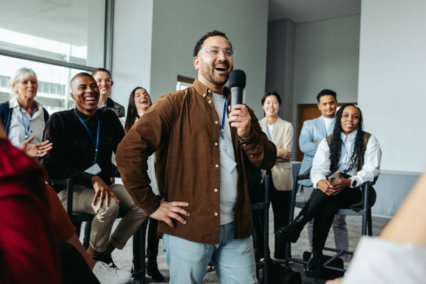A speaker engaging with an enthusiastic audience during a business seminar in a bright, modern conference room.