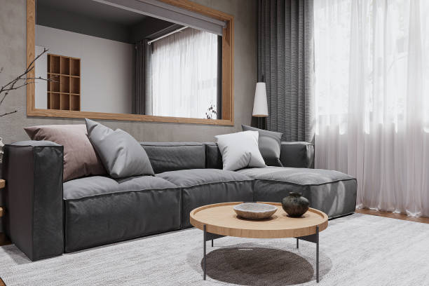 istock A dark gray couch with pillows next to the window, a window covered with gray and white curtains. 2161329498