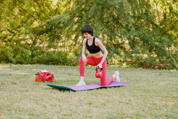 istock A young woman performs an exercise with a  kettlebell outdoors 2161332320