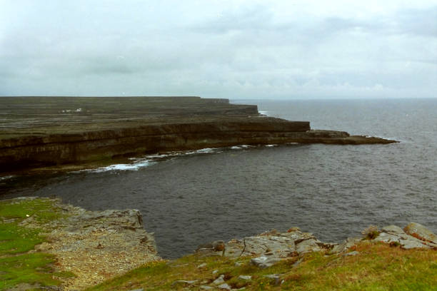 Scenic view of cliff at prehistoric Dun Aengus settlement at Inishmore island on cloudy summer day. Photo taken August 1999, Inishmore, Aran Islands, Ireland.