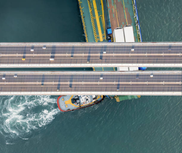 istock Ro-ro ship and tugboat passing under bridge 2161339840