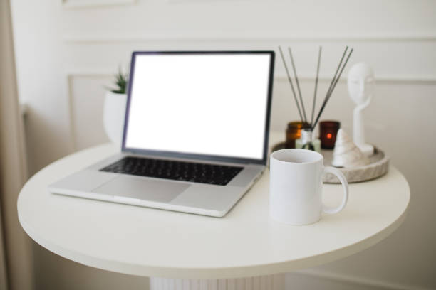 istock Laptop and white mug with tea on a table. Workspace in a modern room. 2161342392