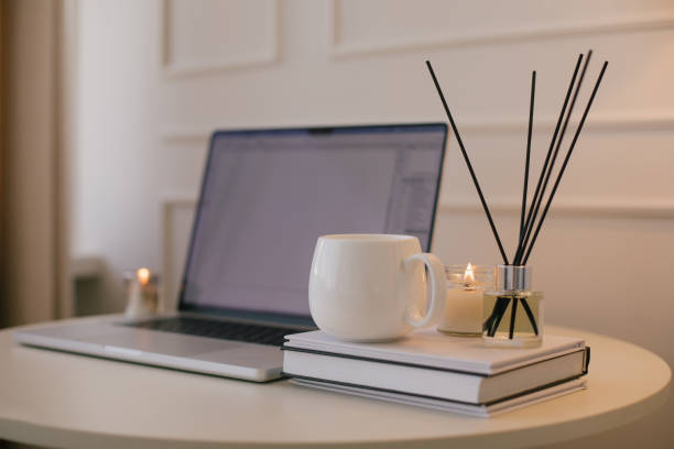 istock Laptop and white mug with tea on a table. Workspace in a modern room. 2161342409