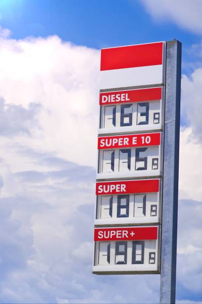 Fuel dispensers show various fuel types, prices while drivers refuel their vehicles at busy urban gas station.