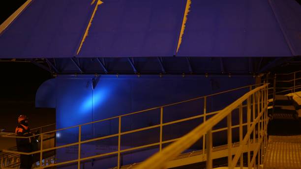 istock Technician at industrial site checks equipment with flashlight. Attentive, skilled technician ensures operational safety and reliability. Nighttime inspection in a complex industrial environment. 2161344623