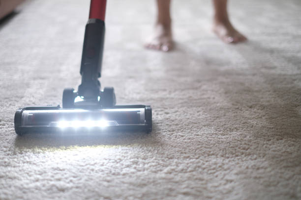 Vacuum cleaner on beige carpet. Cleaning the apartment. Household appliances.