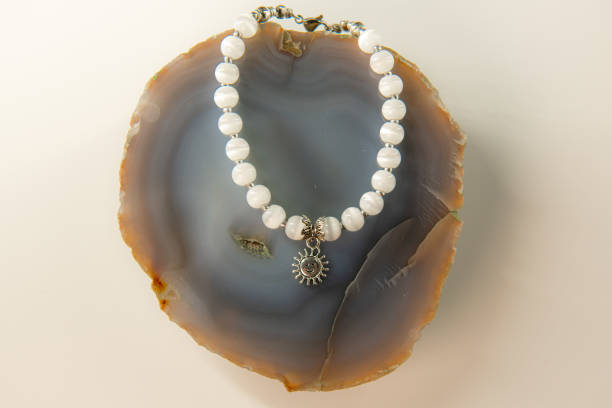 istock White aegate agate necklace on a big agate geode stone on white background 2161349440