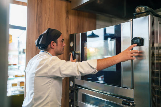 Chef is adjusting the oven for cooking in bakery.