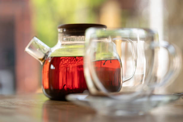 A serene scene glass teapot, herbal tea cups on a sunlit table, creating calming ambiance