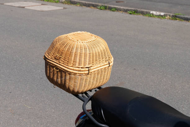 A wicker basket sits on the seat of a parked motorcycle.