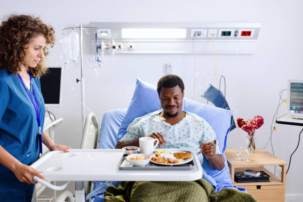 istock Caring nurse giving a meal to her patient 2161353218