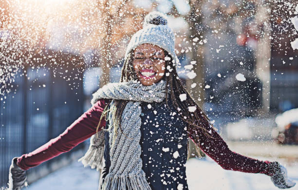 playful, snow and black woman in city, cold and winter with fun, happiness and vacation in new york. person, outdoor and season with girl, cheerful and weather with break, urban town and joy - temperatuur fotos stockfoto's en -beelden