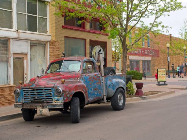 Winslow, Arizona - USA, April 18, 2024. 1949 Studebaker pickup truck on street corner, in downtown Winslow. Visitors crowd the Eagles 'Take It Easy' hit memorial along route 66.