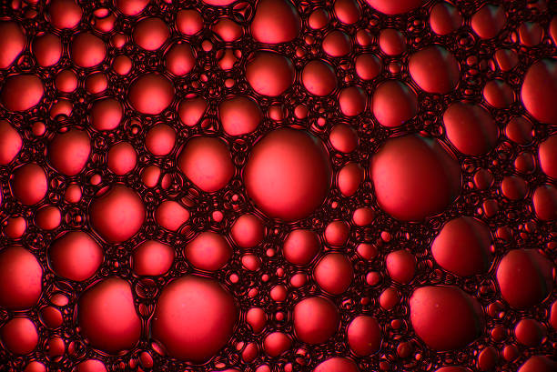 Tablet dissolving in water. Bubbles rise to the surface in a vibrant red liquid. Close-up image highlights the effervescence pill and allure of the drink.