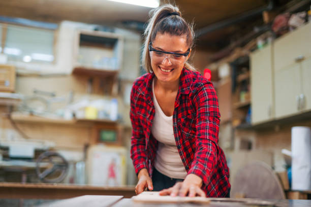 istock young female carpenter cuts a board on a circular saw 2161371047