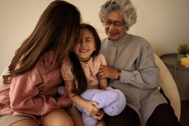 Sad girl lying head on gradmother knees and crying, grandma soothing her, caressing her hair. Portrait of an elderly woman spending time with granddaughter.