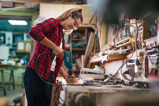 istock young female carpenter  is drilling with a drill. 2161374145