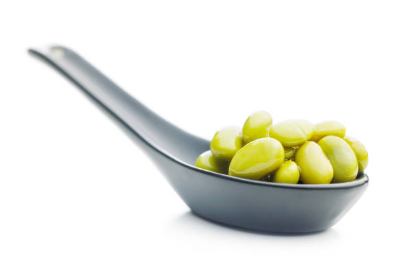 Edamame soy beans in ceramic spoon isolated on a white background.