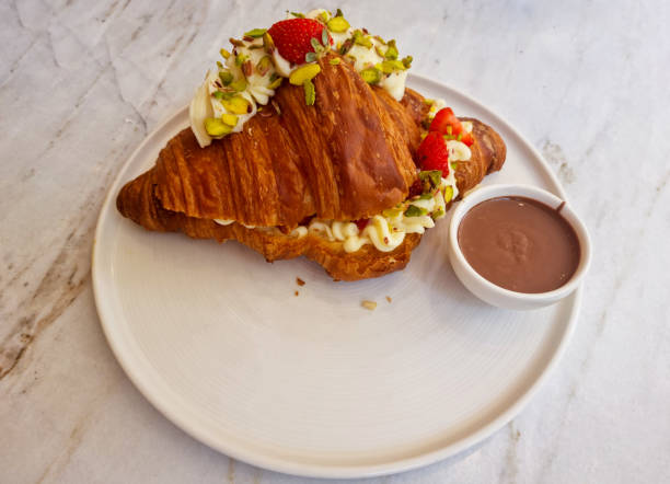 Taking one croissant to serve on the table for breakfast