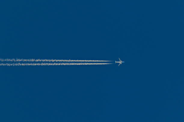 istock jetliner crossing the cloudless blue sky leaving a vapor trail. 2161378901