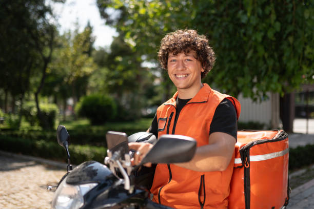 istock Male Courier on Motorcycle in the Park 2161380874