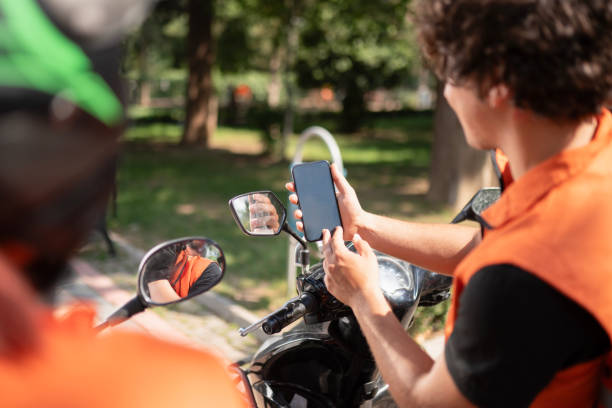 istock Couriers Chatting and Showing Something on Phone While Sitting on Motorcycles 2161381608