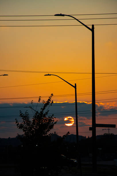 Sun at sunset in the middle of power cables