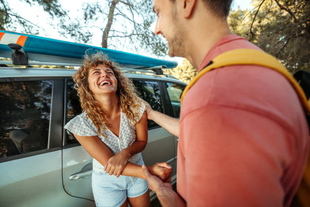 istock Young couple bonding while standing near their car 2161384013