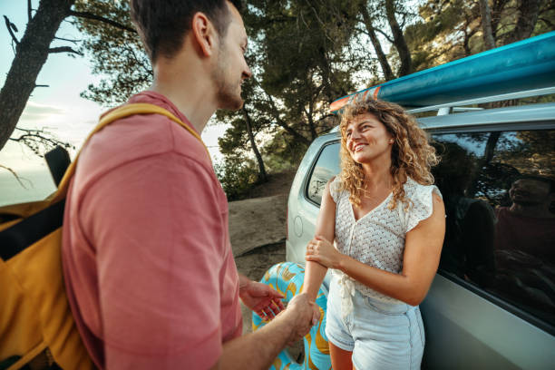 istock Young couple bonding while standing near their car 2161384014