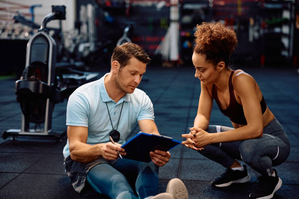 istock Personal instructor and sportswoman analyzing exercise plan in a gym. 2161387174