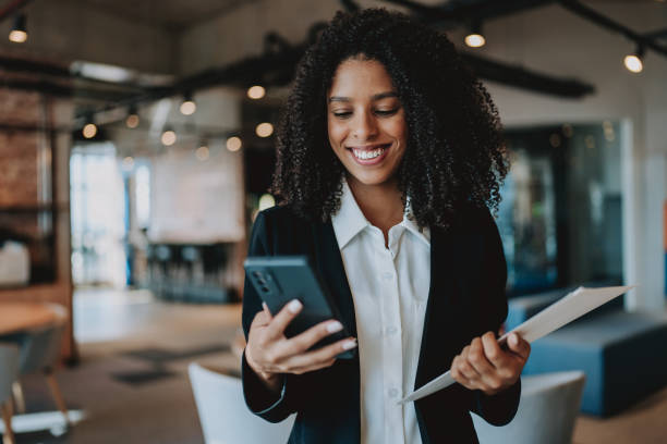 istock Young businesswoman holding smartphone at work 2161387313
