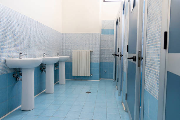 room with blue tiles, with sinks on the left, radiator on the front wall and blue aluminum doors