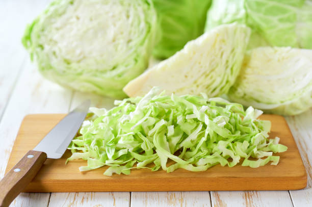 istock Whole and shredded cabbage on light wooden table. 2161391294