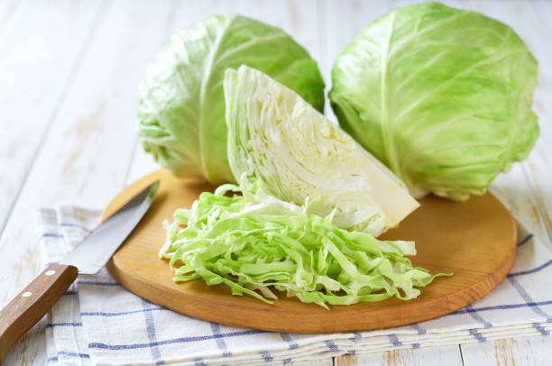 istock Whole and shredded cabbage on a cutting board. 2161391296