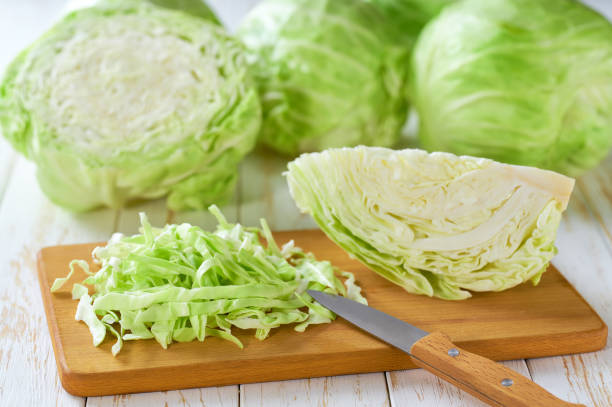istock Whole and shredded cabbage on light wooden table. 2161391299