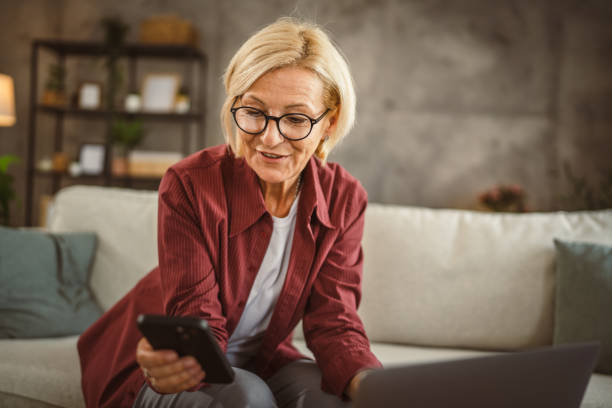 istock Mature senior woman work from home and use mobile phone on break 2161392702